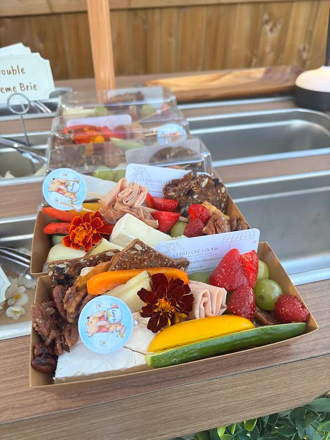 Individual charcuterie servings with cheese, fruit, vegetables and crackers